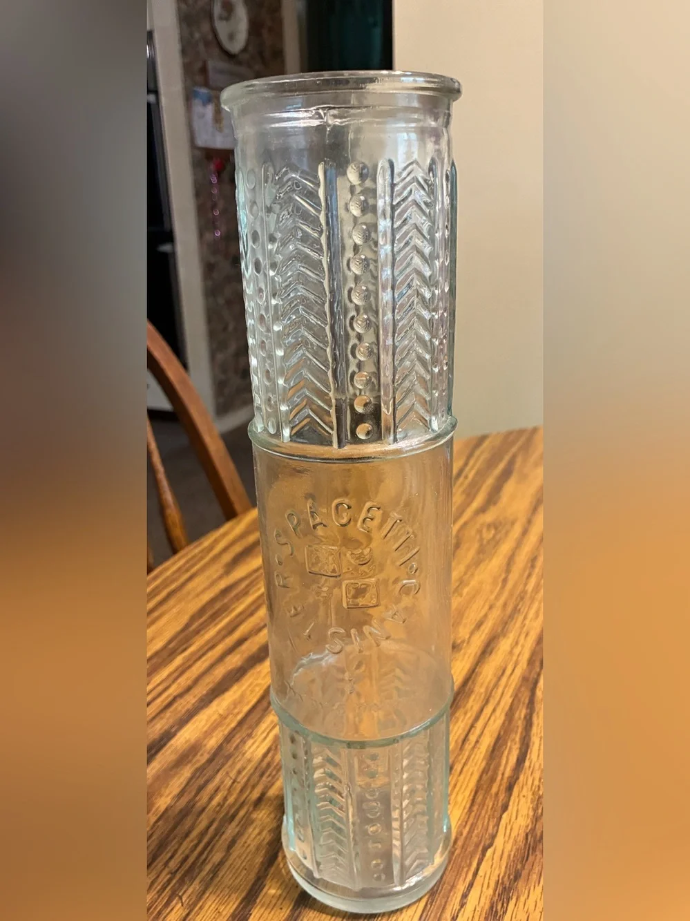 vintage glass spaghetti canister features an embossed circular logo